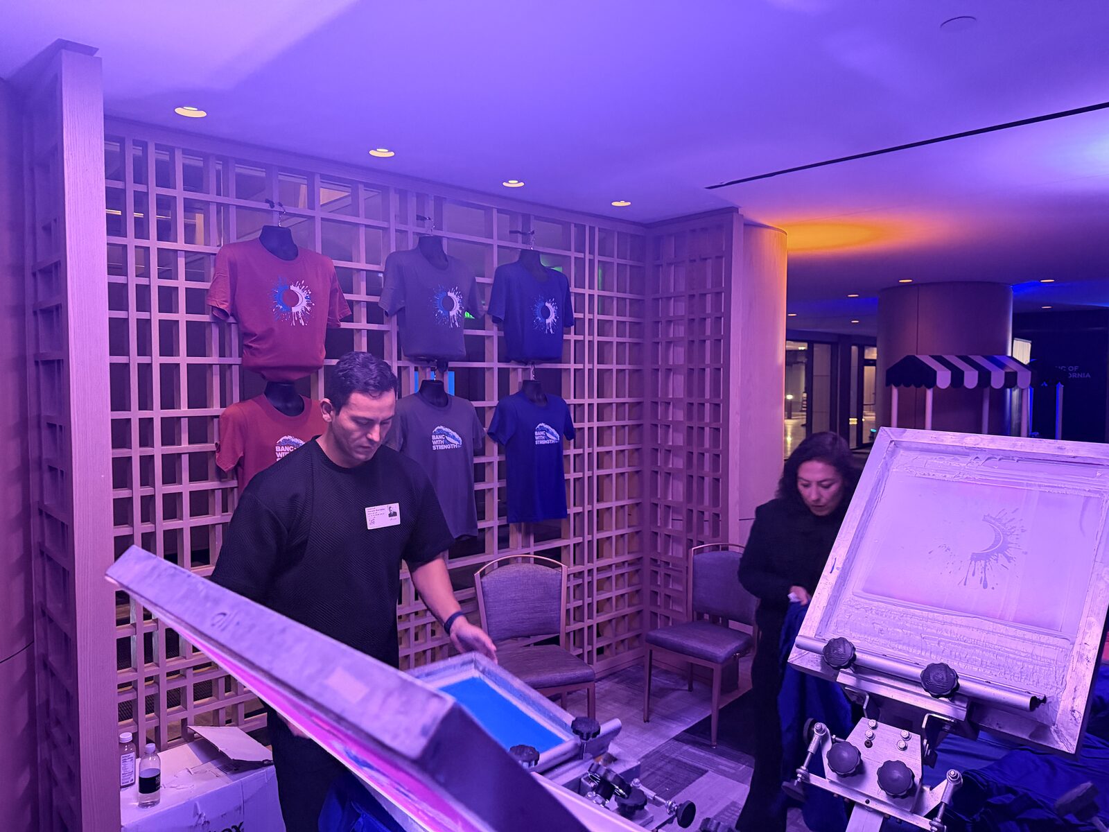 Wall of printed event shirts on display