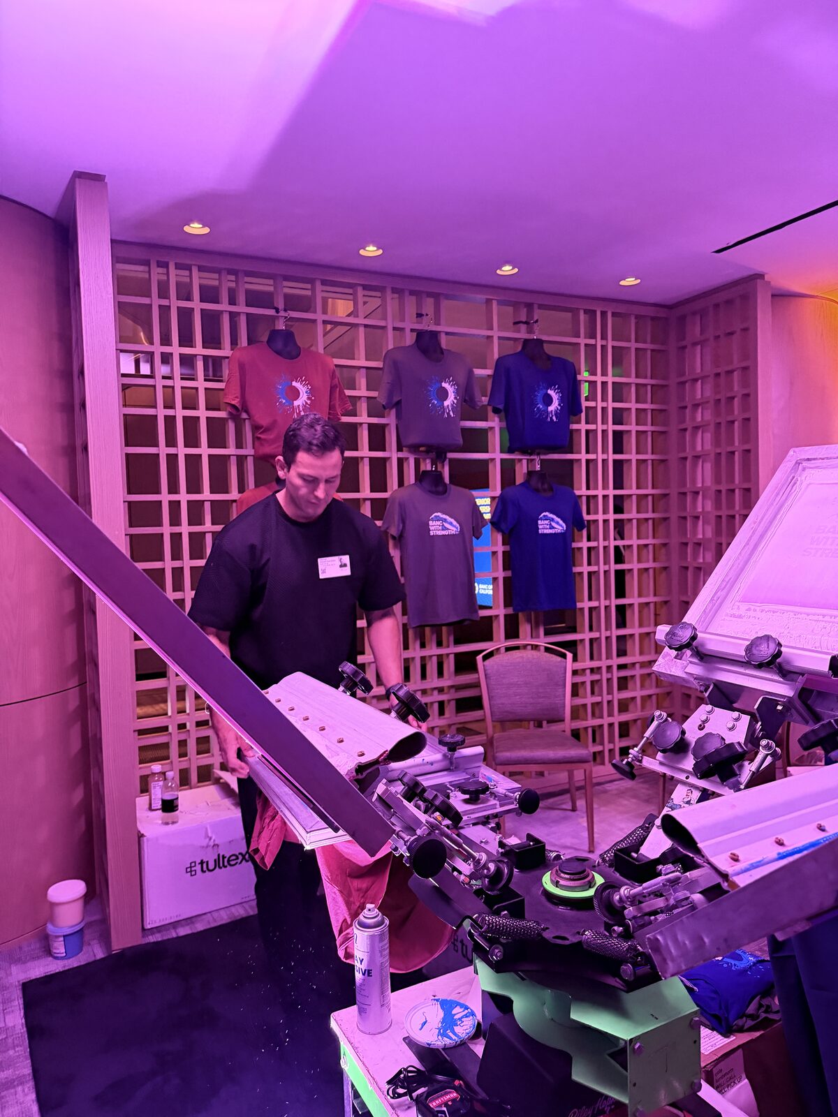 Operator loading a blank shirt onto an on-site press